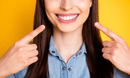 Woman smiling with bright white teeth after professional Zoom whitening treatment