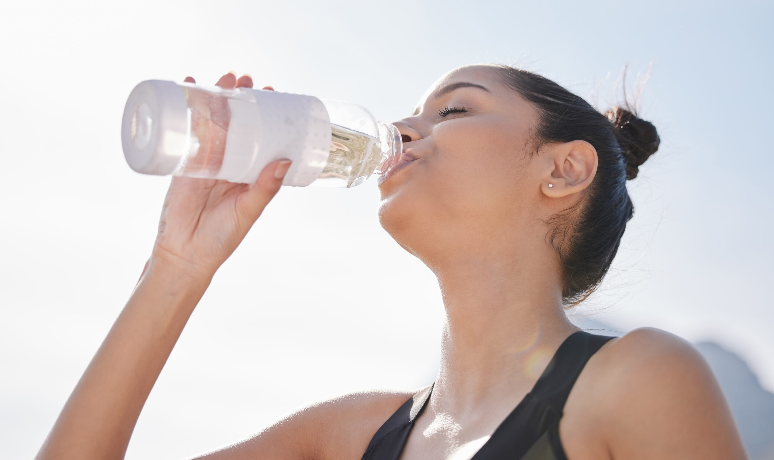 Woman drinking a glass of water to relieve dry mouth